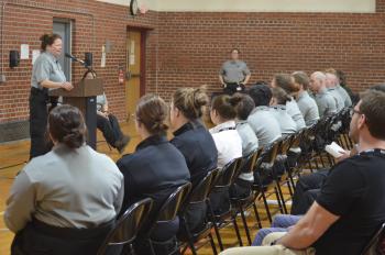 Training Specialist DeMary-Newman speaking to the graduates of class 219.